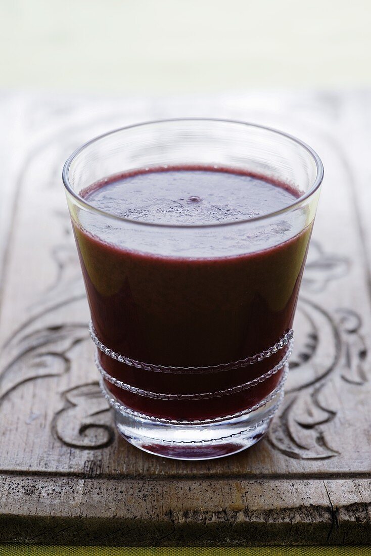 A glass of apple, blackberry and pear juice