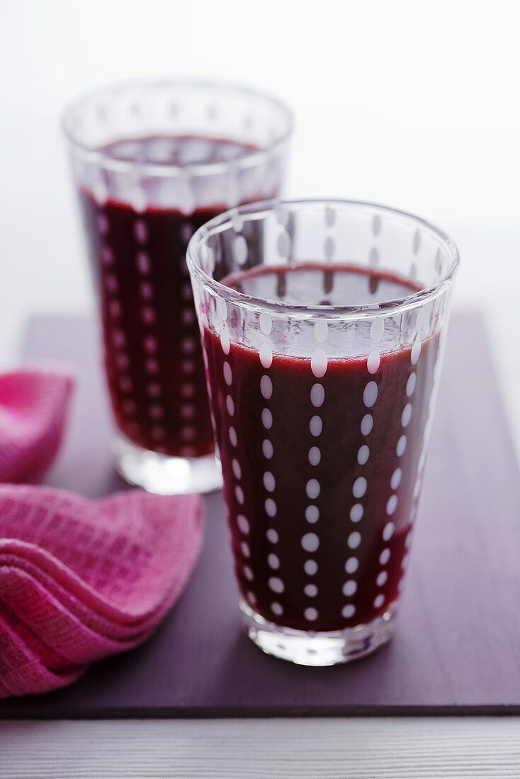 Two glasses of apple, blackberry and cucumber juice