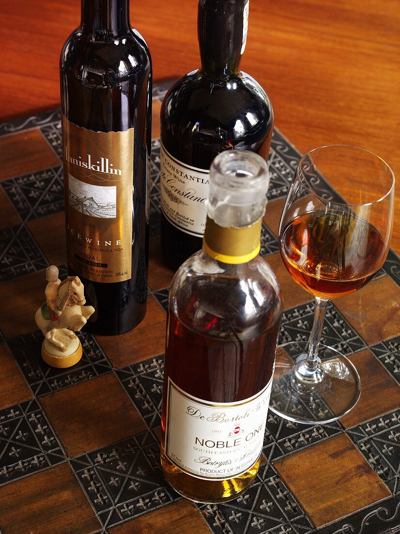 Various bottles of wine and glass of wine on chessboard