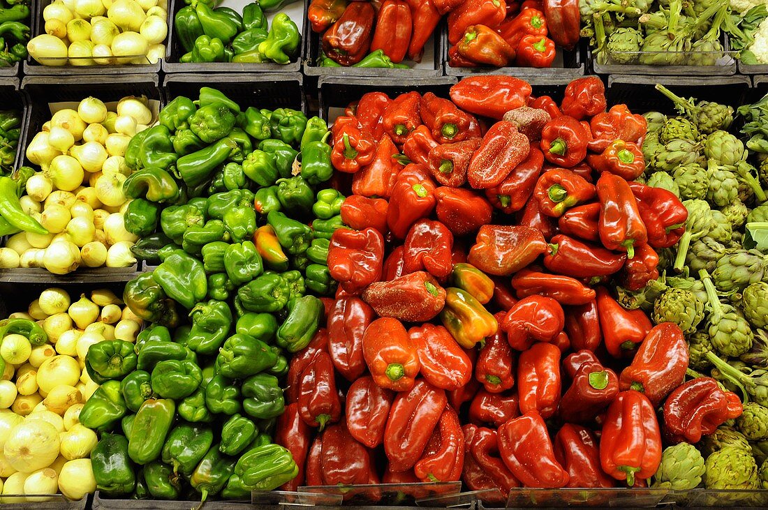 Verschiedene Paprikaschoten, Zwiebeln und Artischocken auf dem Markt