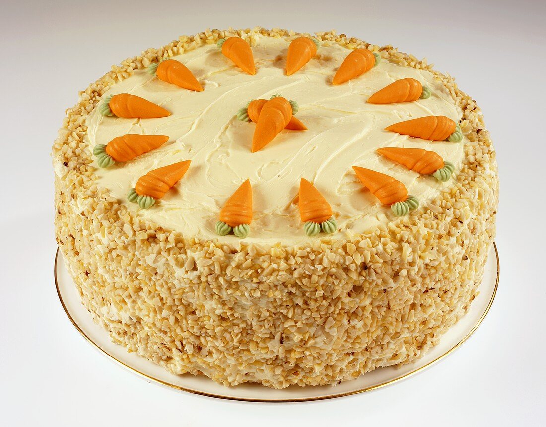 A whole carrot cake with chopped nuts