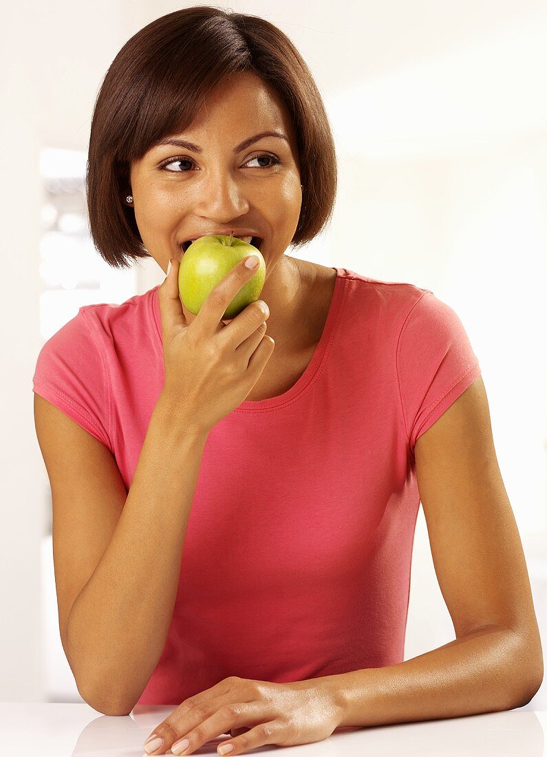 Woman eating green apple