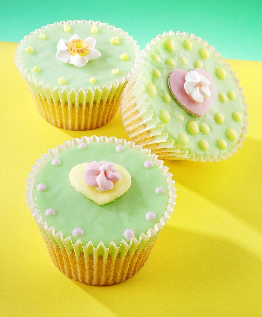 Cupcakes mit grüner Glasur und Zuckerblüten