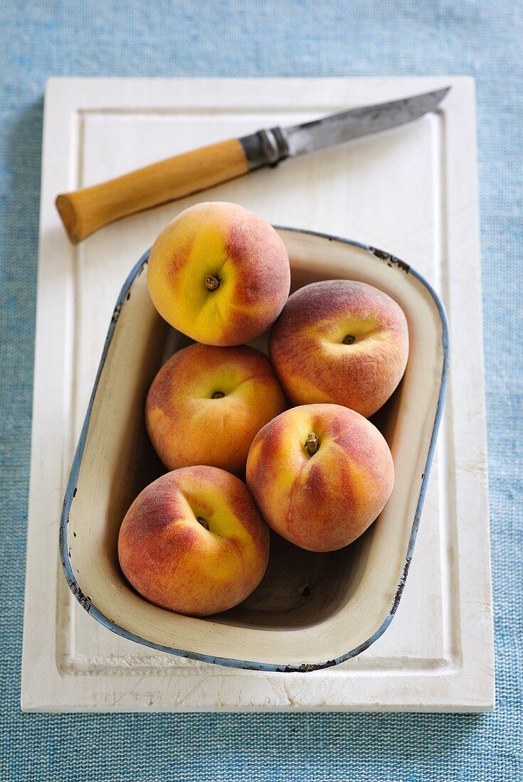 An enamel bowl of peaches