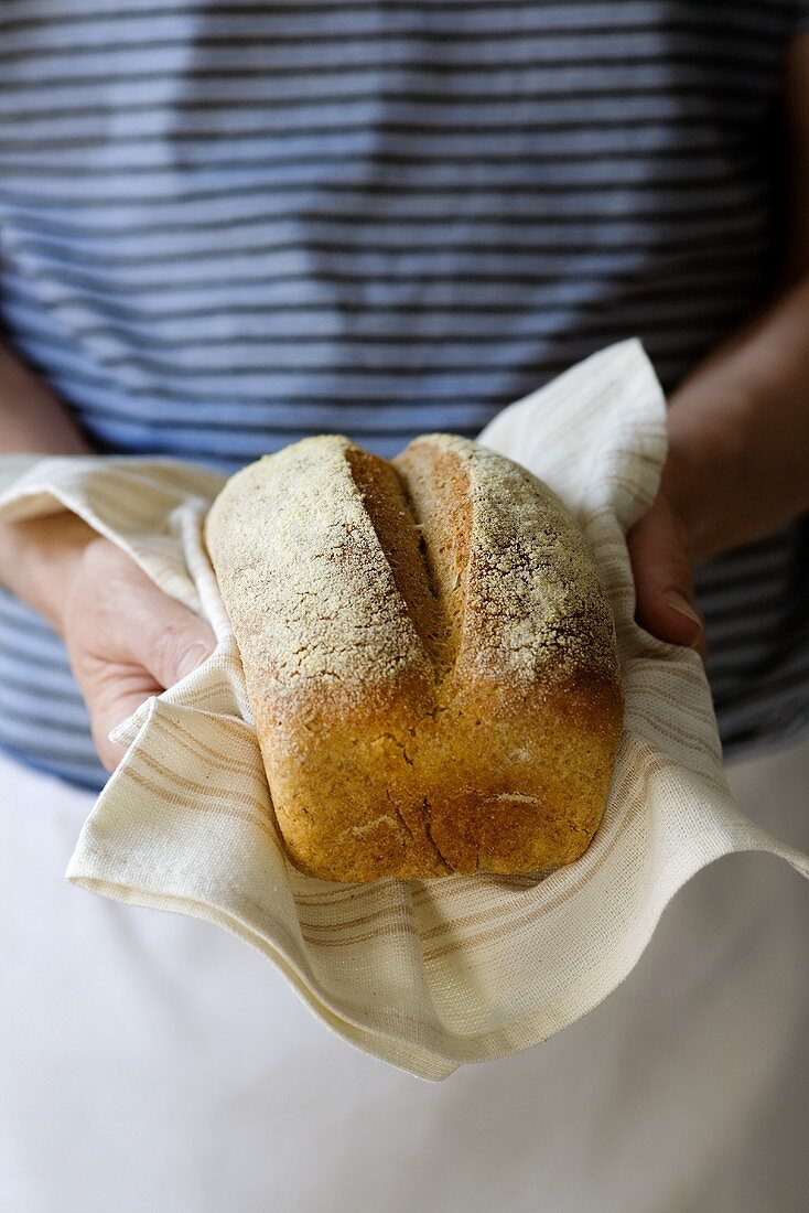 Person hält frisch gebackenes Roggenbrot