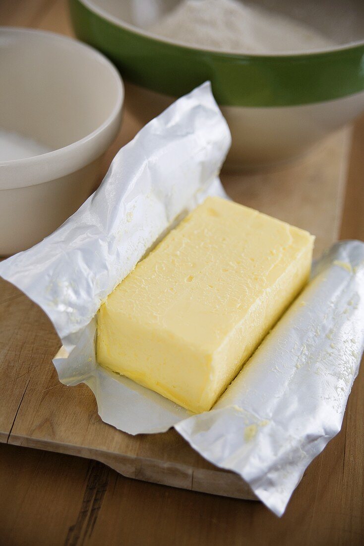 Butter in paper with other baking ingredients in the background