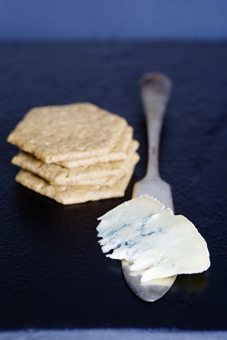 A piece of blue cheese (Mrs Temple's Binham Blue, Norfolk, UK) and crackers