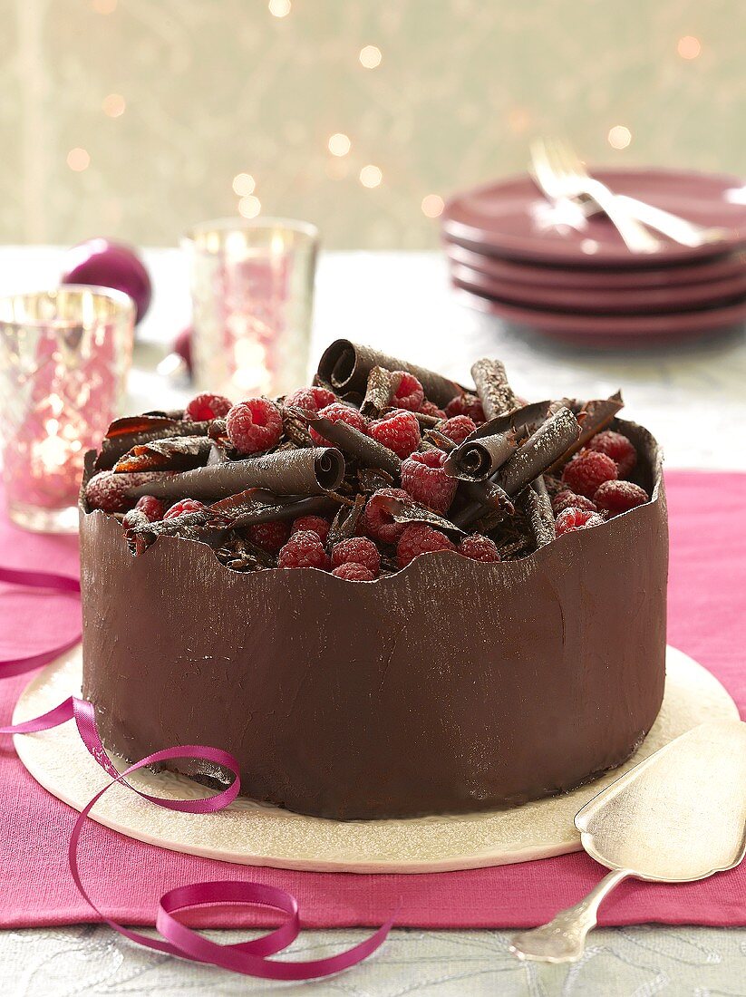 A chocolate cake with raspberries and chocolate curls