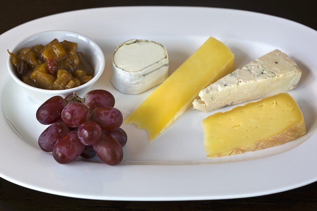Cheese plate with grapes and pickles