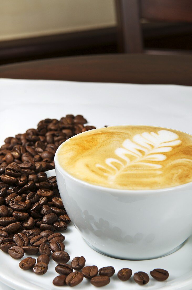 Cappuccino-Tasse und Kaffeebohnen