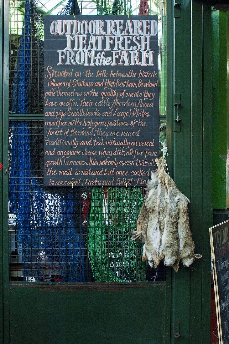 Rabbits hanging by a market sign (England)