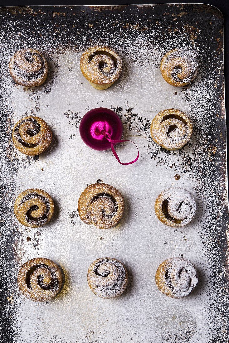 Mince pies with icing sugar and a Christmas bauble