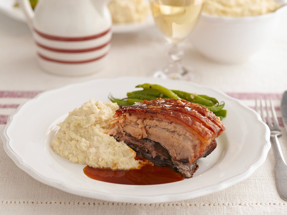 Crispy roast pork belly with mashed potatoes and green beans