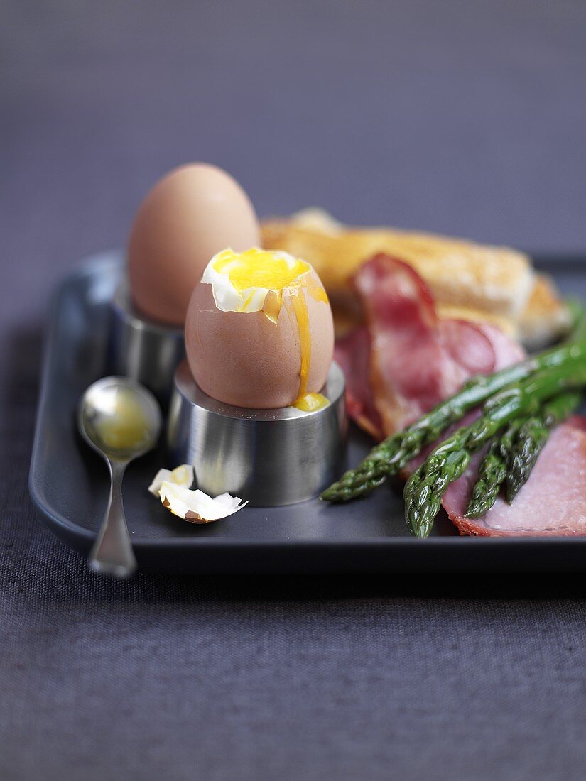 Gekochte Eier mit grünem Spargel und Schinken