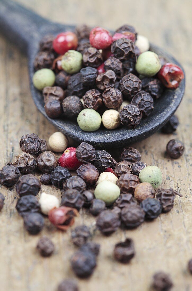 Various peppercorns with a wooden spoon