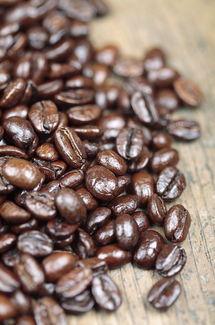 Viele geröstete Kaffeebohnen auf Holzuntergrund