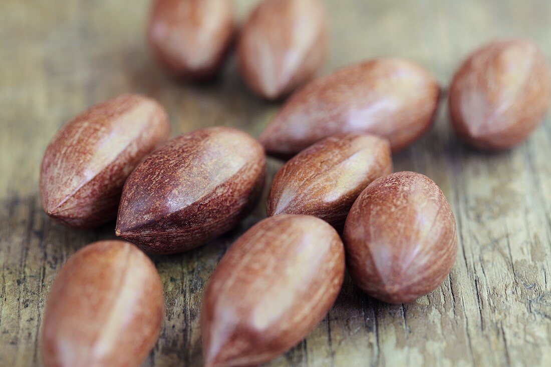Whole pecan nuts on a wooden surface