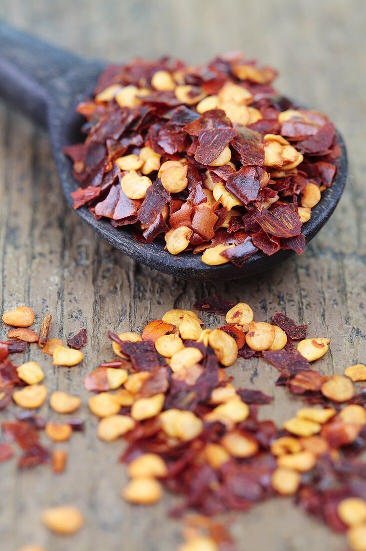 Dried chilli flakes with a wooden spoon
