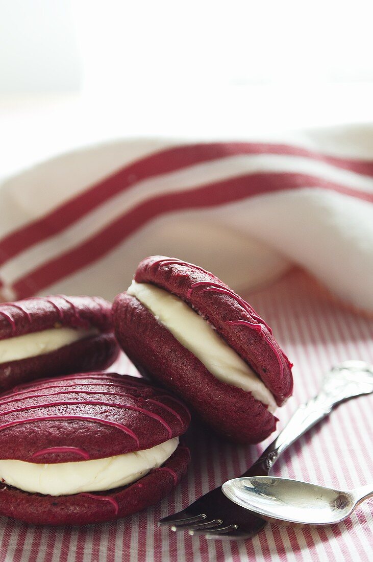 Raspberry whoopie pies with a tea towel in the background