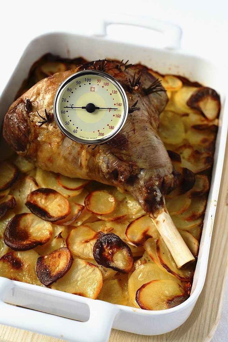 Roasted leg of lamb on a bed of sliced potatoes