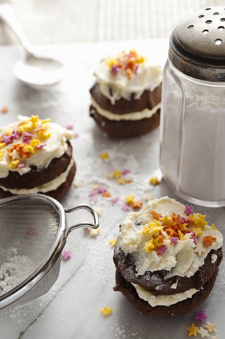 Chocolate whoopie pies with cream, icing sugar and sugar stars