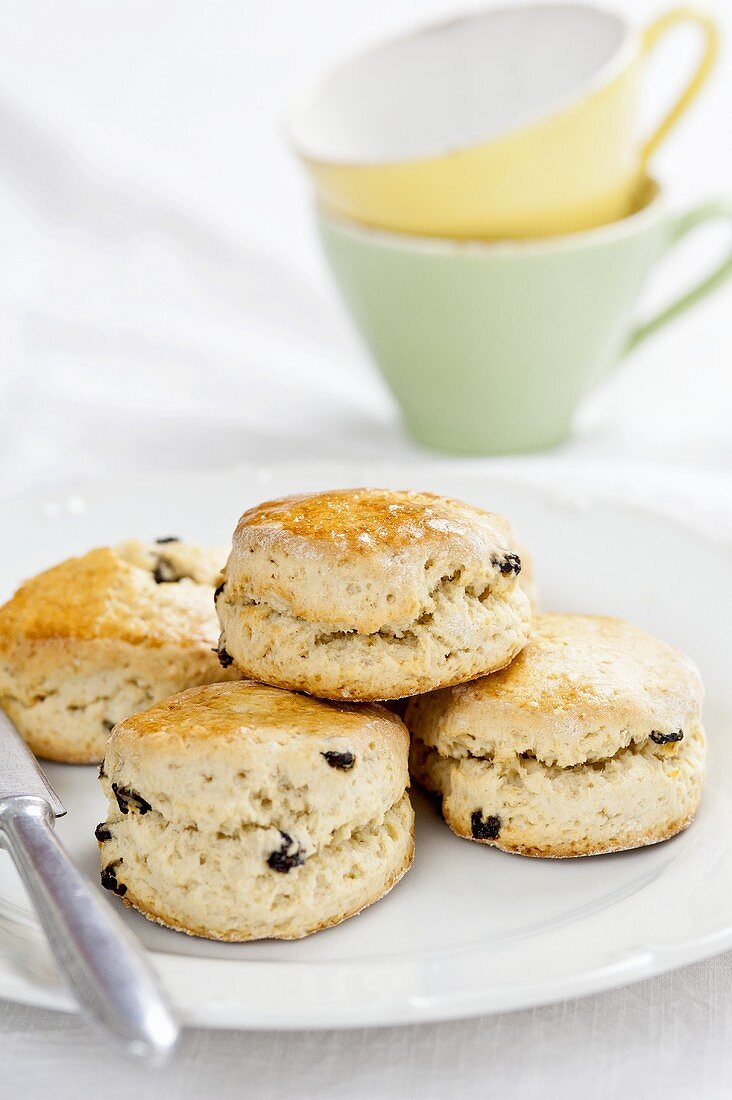 Scones mit Rosinen auf Teller vor Teetassen