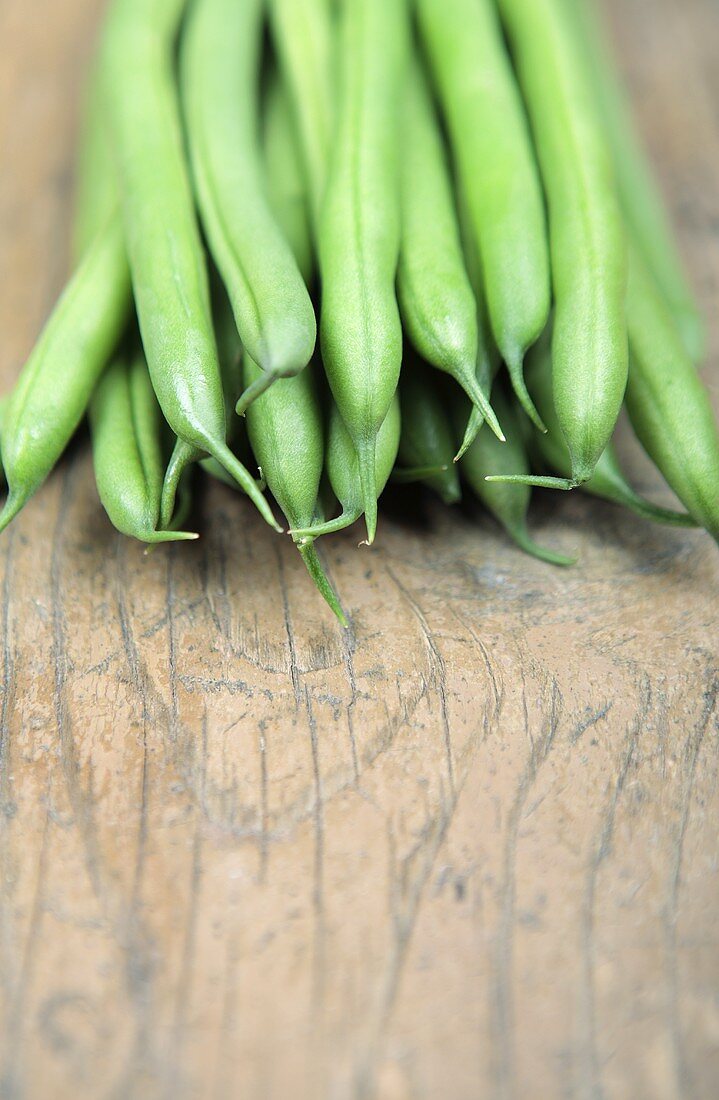 Green beans on a wooden background