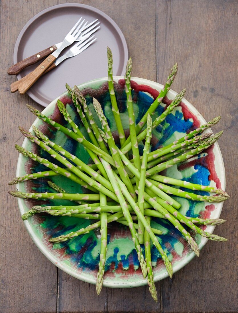Fresh green asparagus stalks in a dish