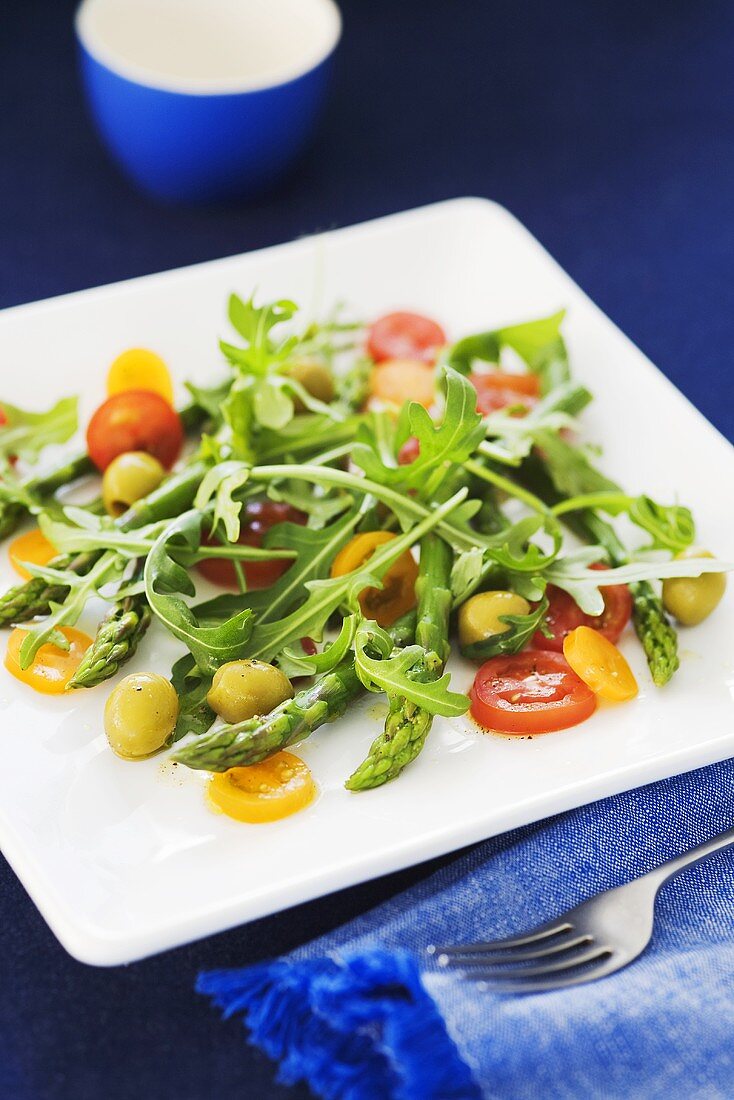 Asparagus salad with rocket, cocktail tomatoes and olives