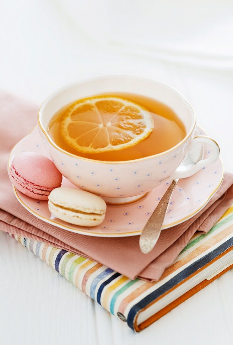 Eine Tasse Zitronentee und Macarons