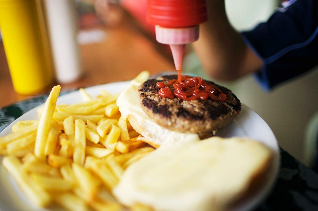 Hamburger mit Ketchup beträufeln