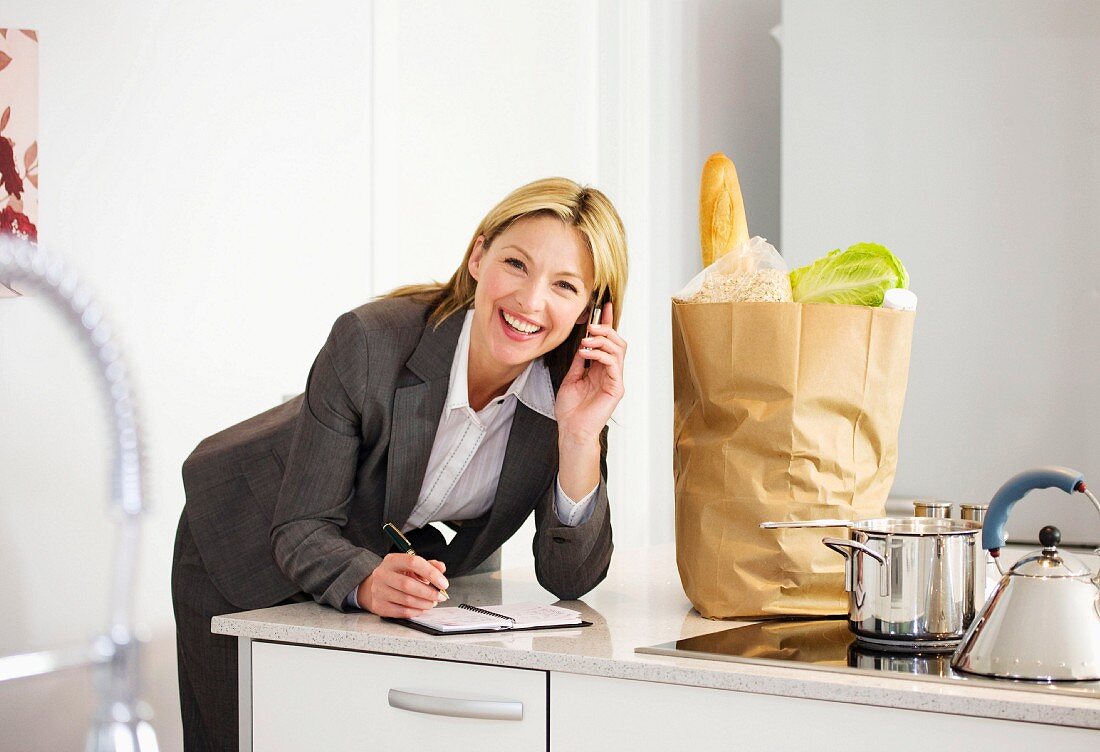 Woman with bag of shopping in kitchen