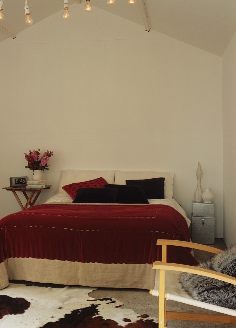 Schlafzimmer mit Doppelbett und Kuhfell als Bettvorleger