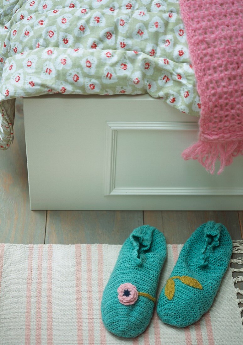 Crocheted slippers at foot of bed