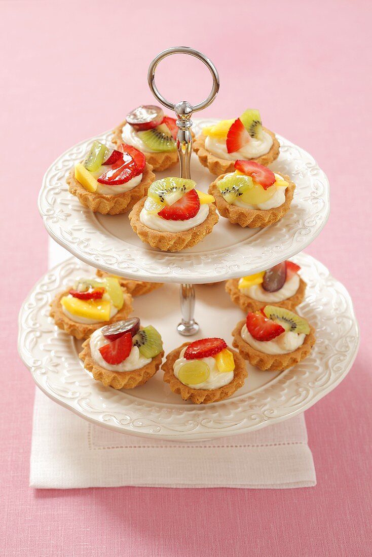 Mini fruit tartlets with vanilla cream on a cake stand