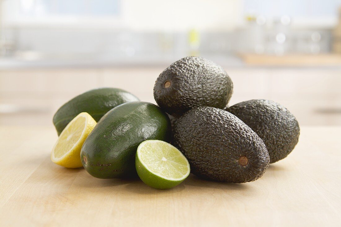 An arrangement of avocado, lime halves and lemon halves