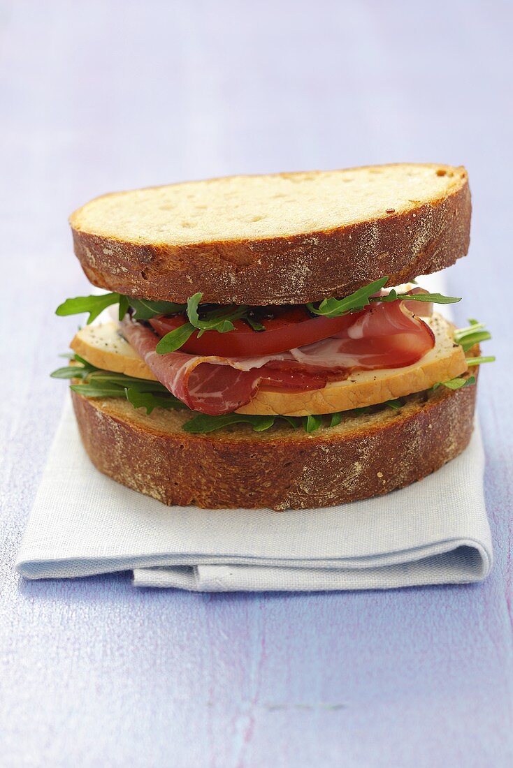 Vollkornbrot-Sandwich mit Räucherkäse, Schinken & Rucola
