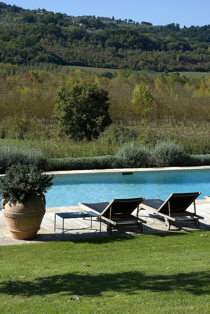 Liegestühle am Pool mit Landschaftsblick