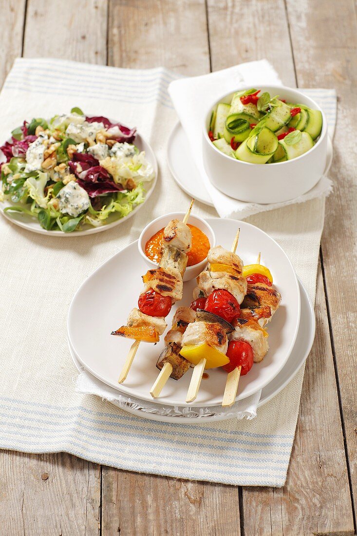 Grilled kebabs with chicken and vegetables and salads