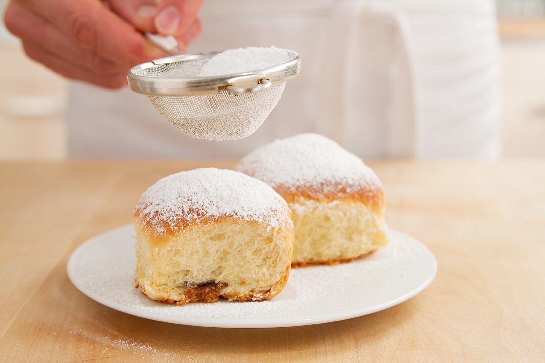 Buchteln mit Puderzucker bestäuben