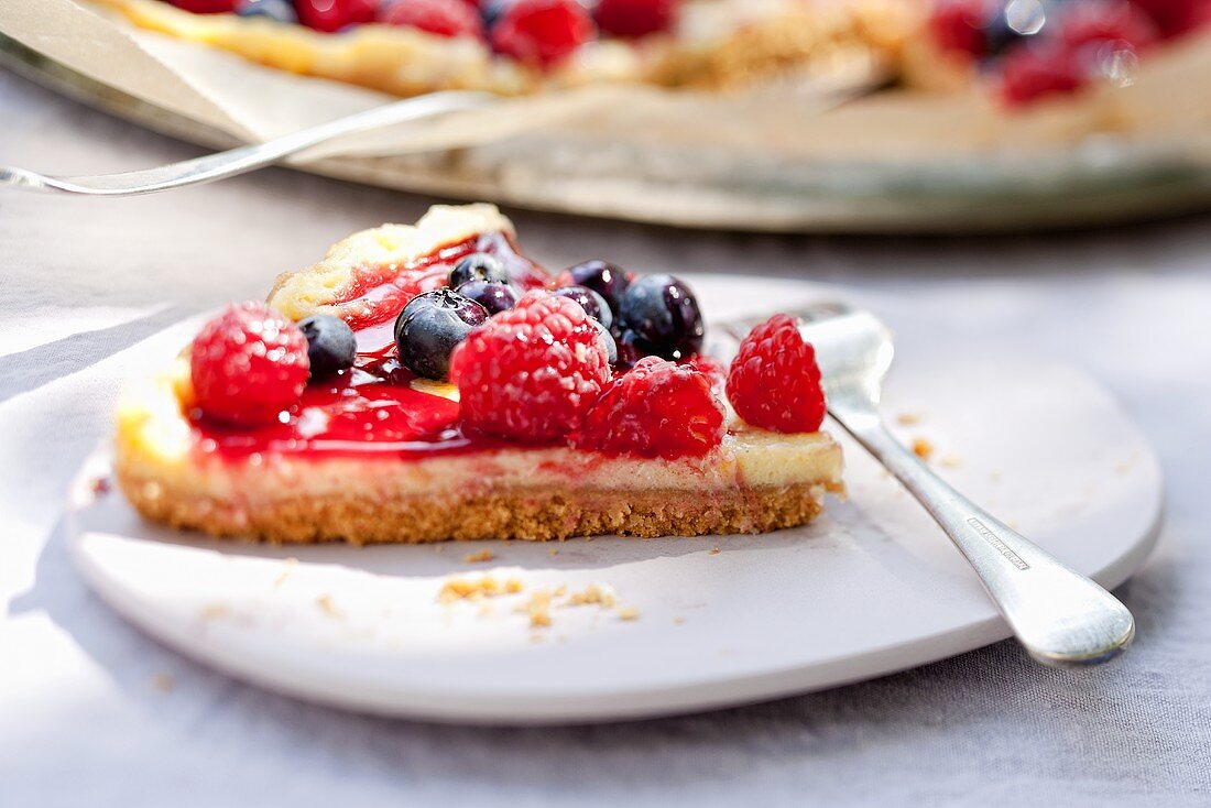 Ein Stück Mascarponetarte mit frischen Beeren