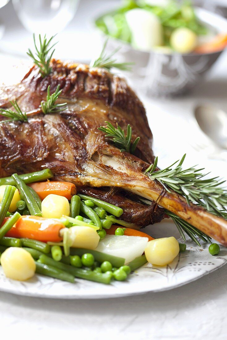 A leg of lamb with rosemary and a side of vegetables