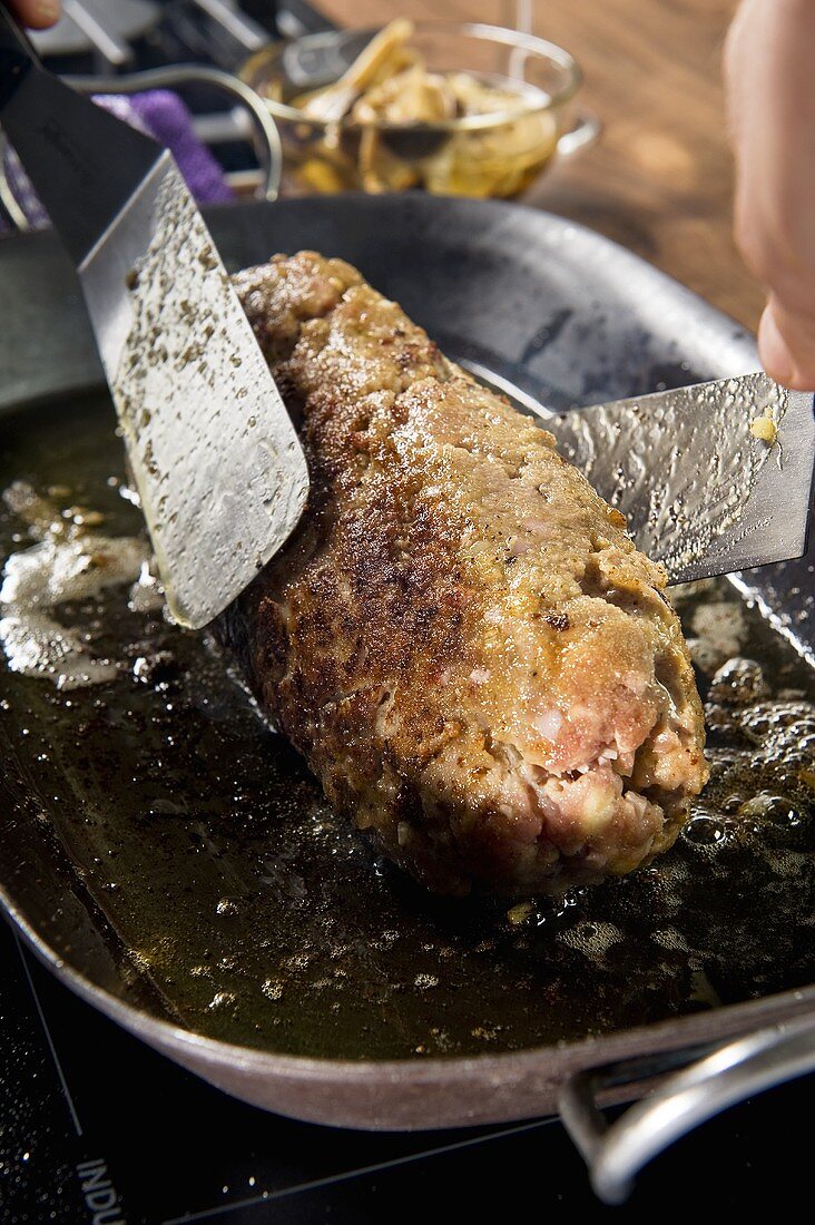 Polpettone con porcini (meat loaf with porcini mushrooms being fried)