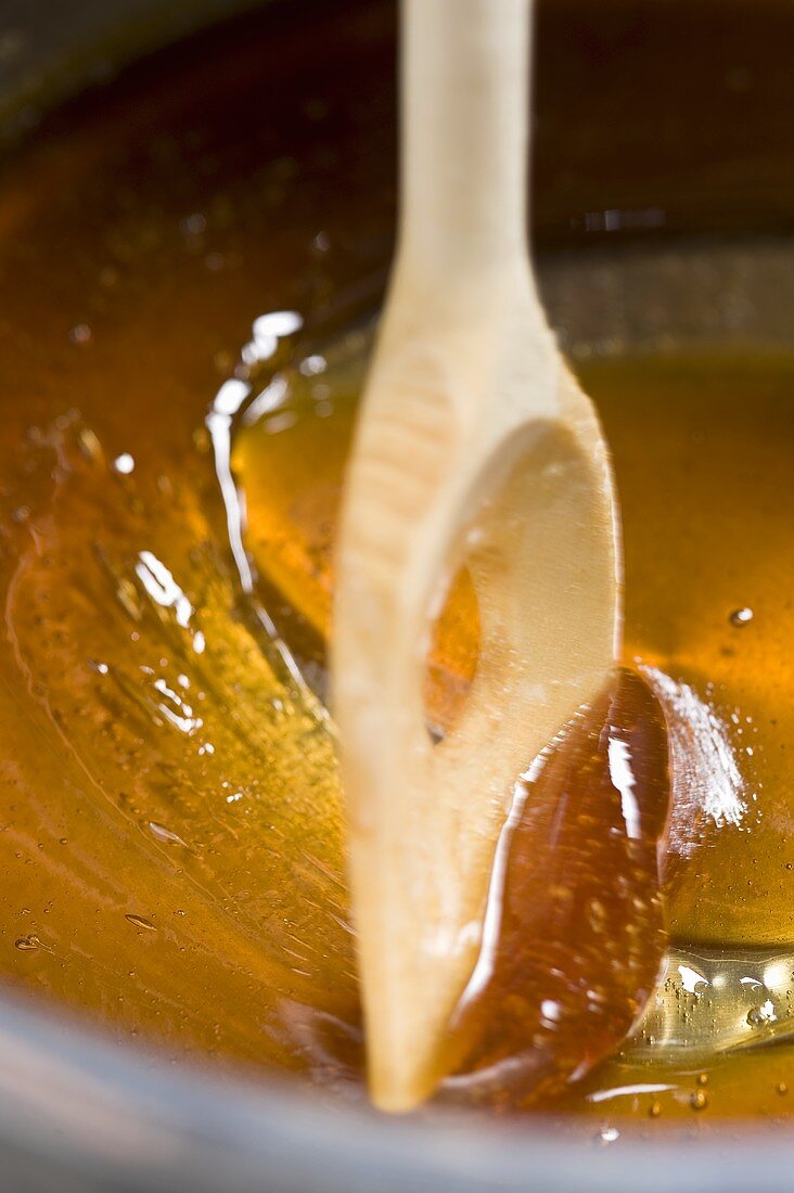 Caramel being made from sugar and honey by stirring