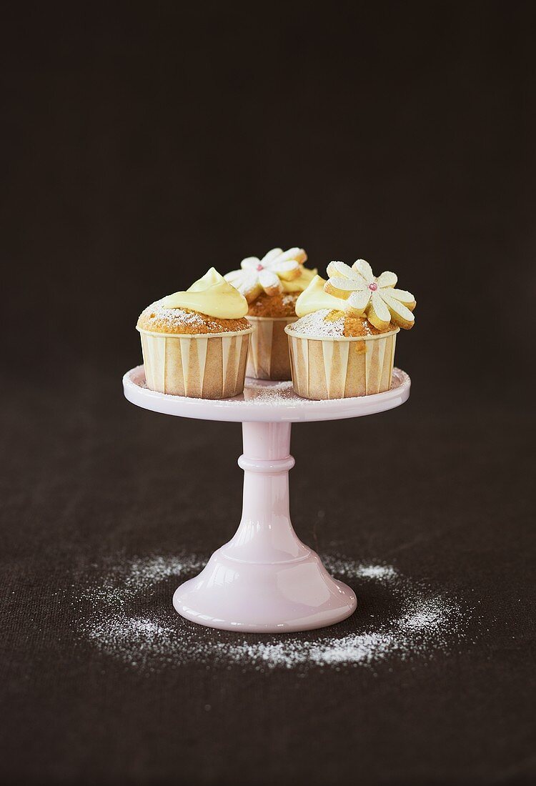 Cupcakes decorated with dough flowers and cream