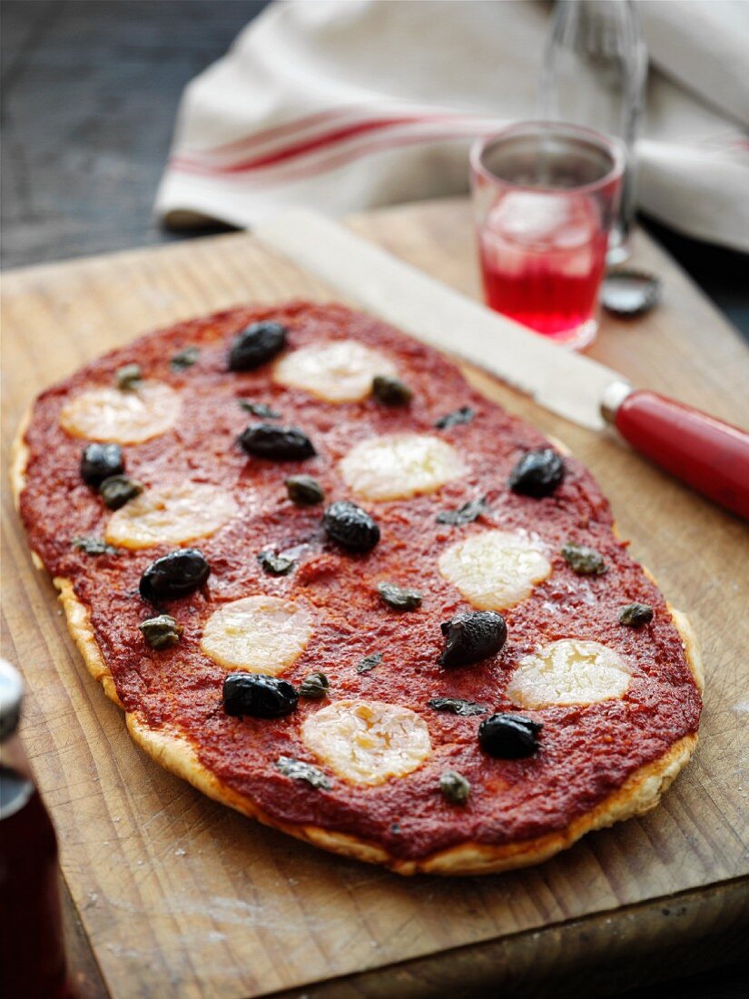A pizza with tomato sauce, olive and bocconcino