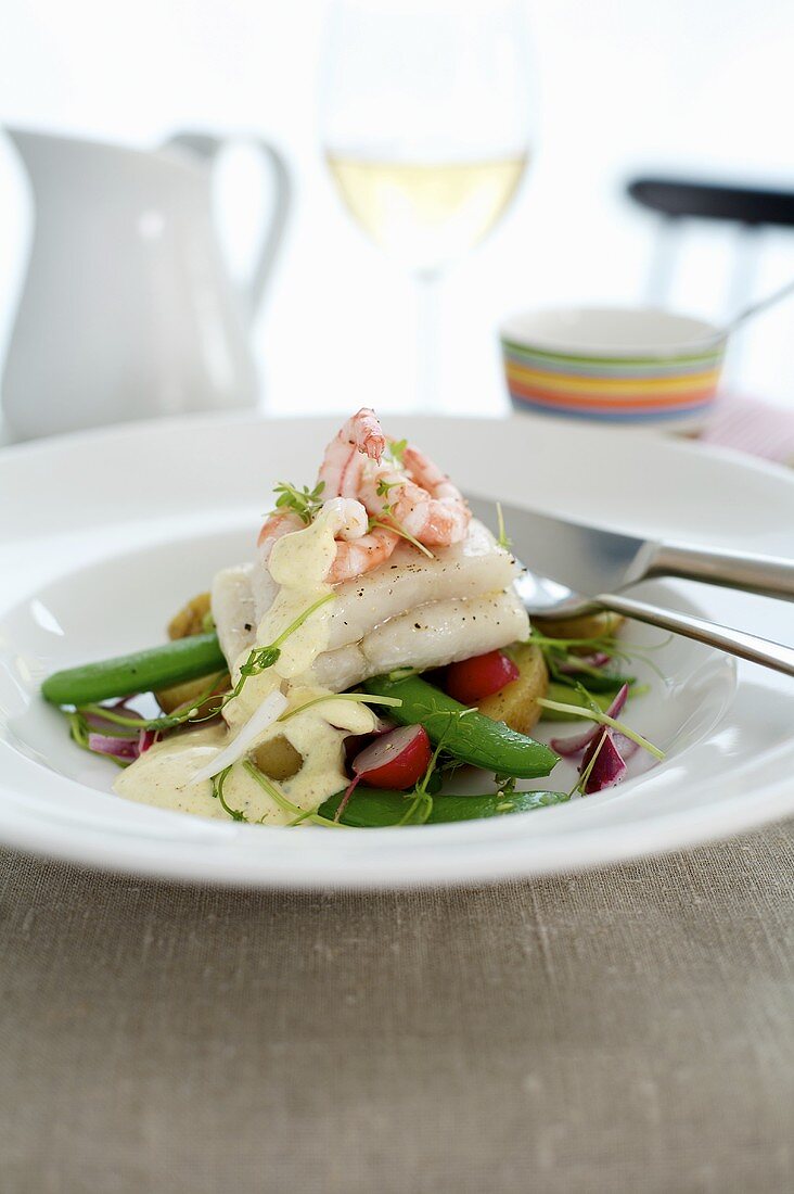 Fischfilet und Garnelen auf Kartoffelsalat mit Gemüse