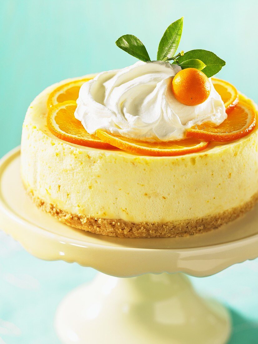 A whole orange cheesecake on a cake stand