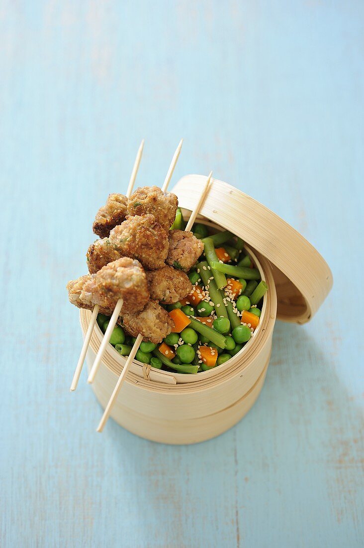 Breaded veal kebabs with bran and steamed vegetables