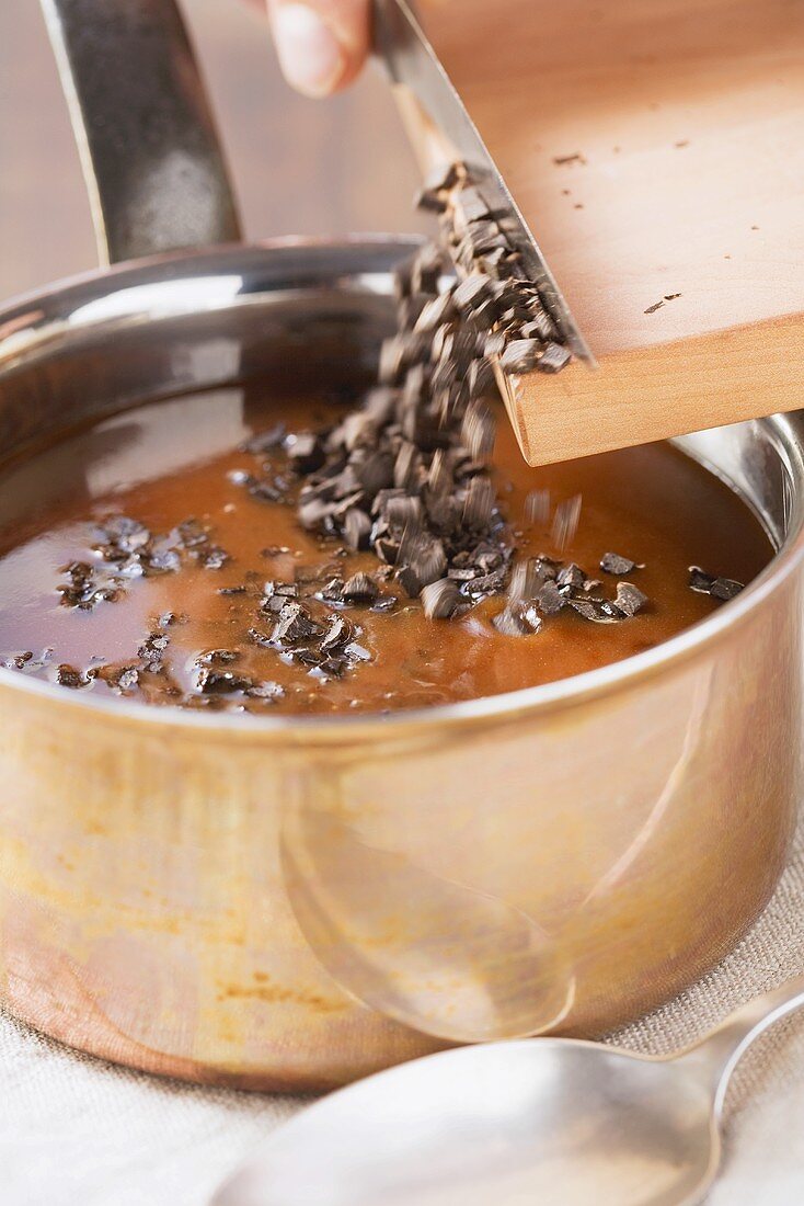 Truffle sauce being prepared: diced truffles being added